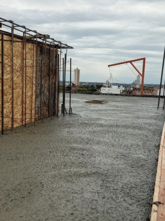 Concrete pour of the rooftop terrace slab at Residencias del Sol with the Asuncion skyline