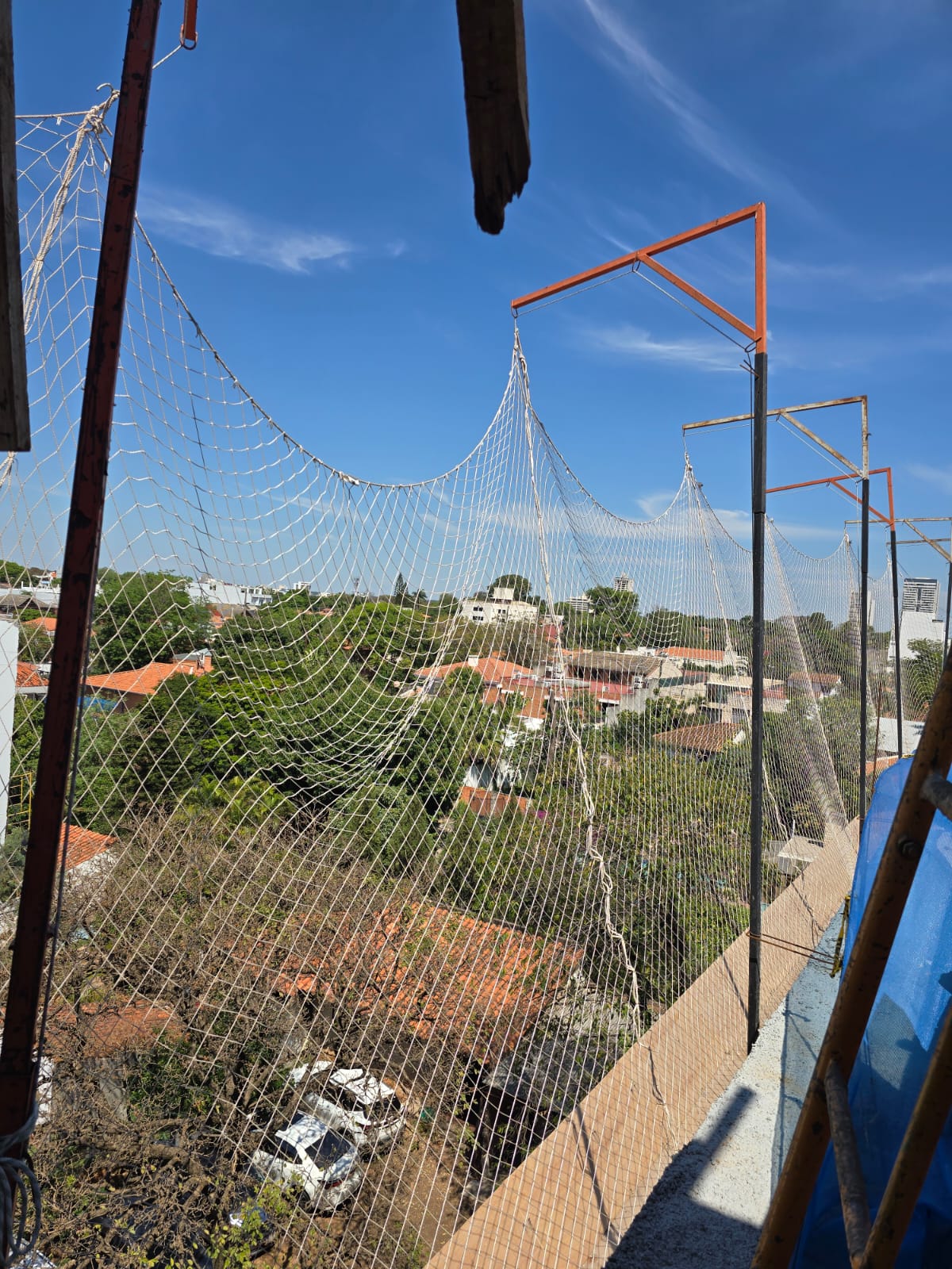 Baustelle von Residencias del Sol mit Schutznetz und Blick auf die Gebäude von Asunción