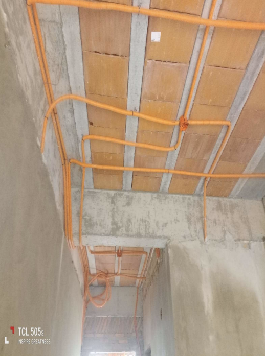 Orangefarbene Elektroinstallationsrohre an einer Decke in Residencias del Sol